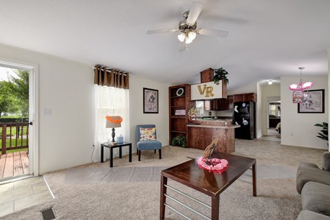 a living room with a ceiling fan and a coffee table